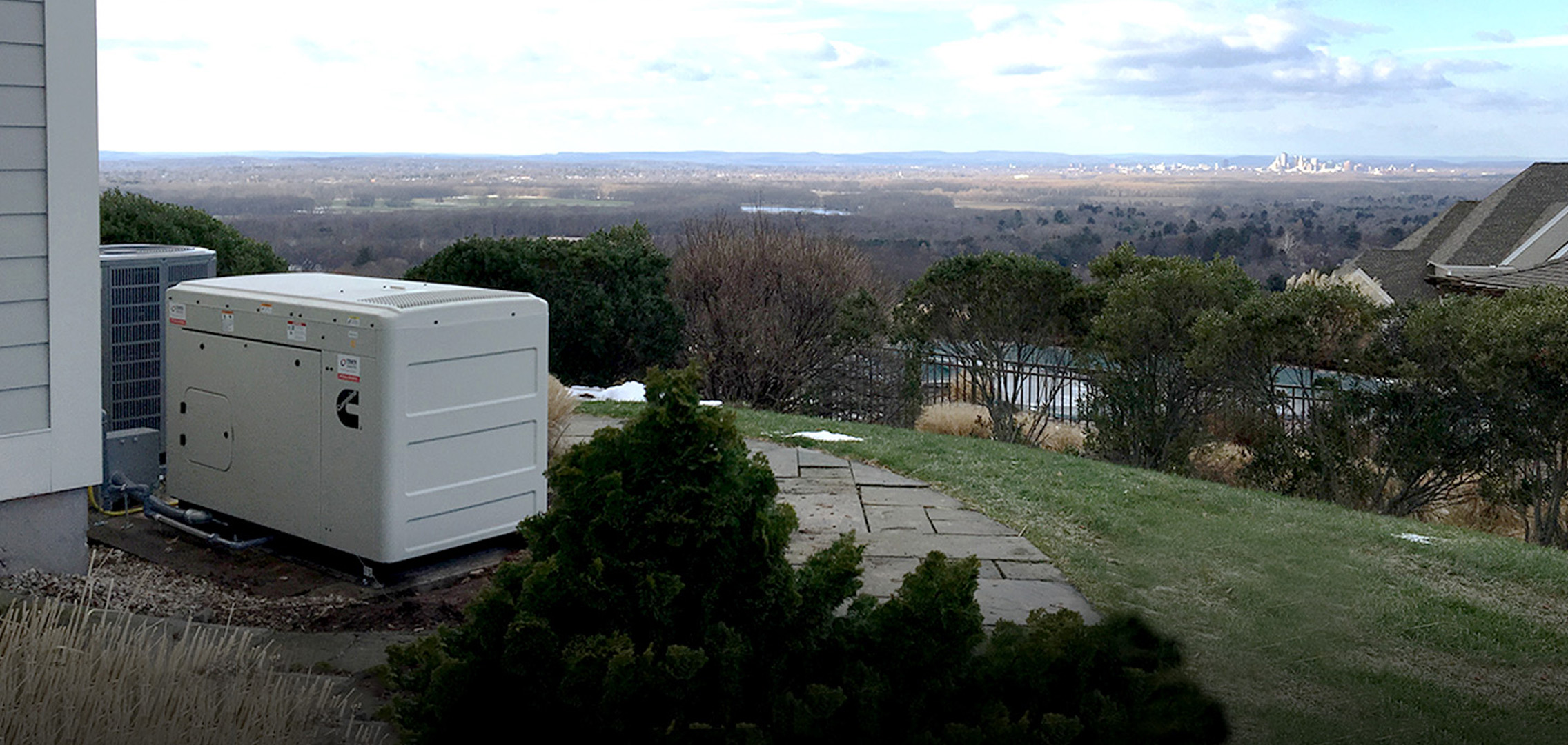 Residential generator in the foreground overlooking a forests and Hartford in the background