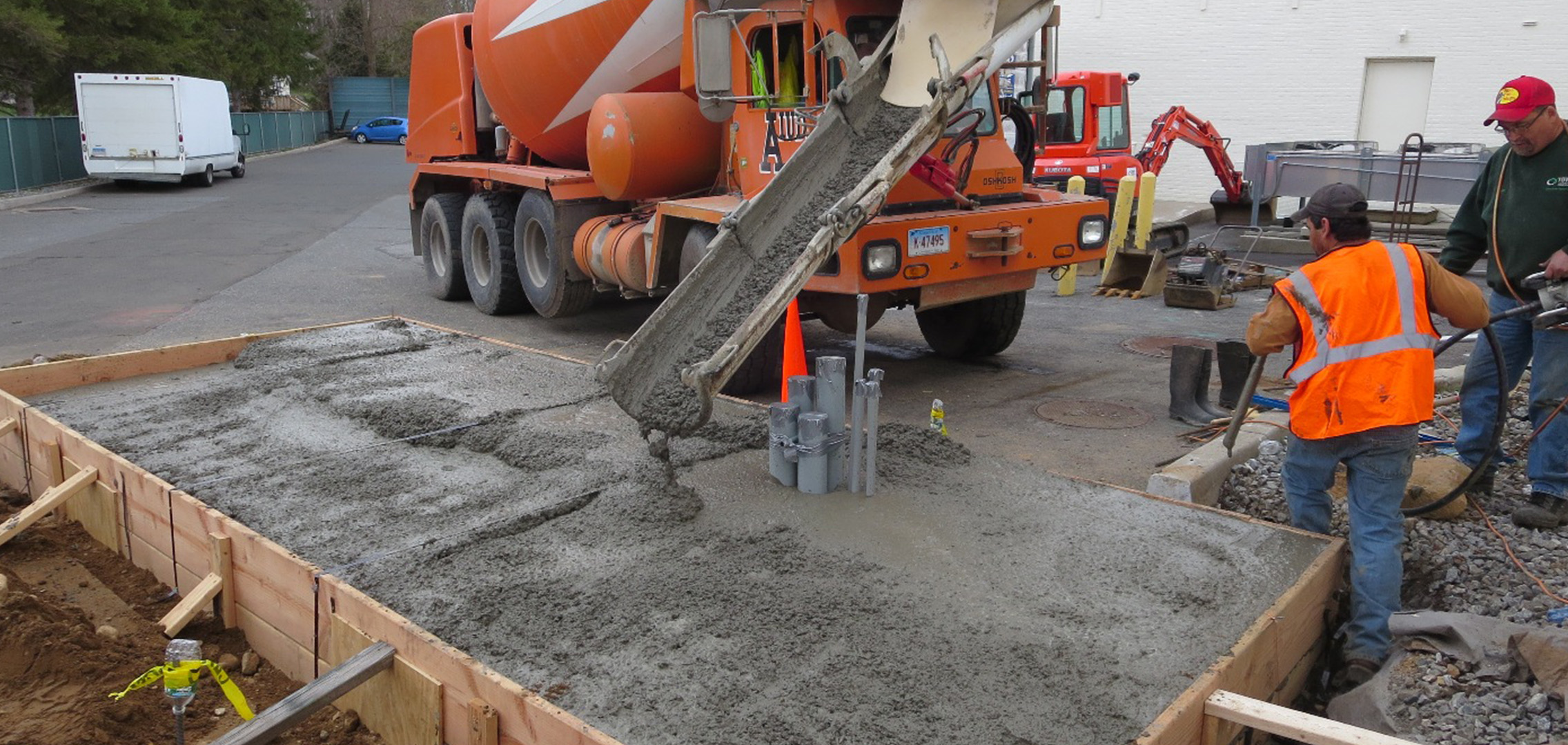 Concrete being poured into the large wooden frame