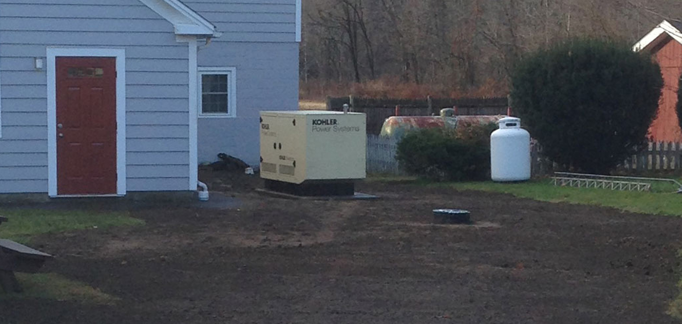 Newly installed commercial generator next to tank