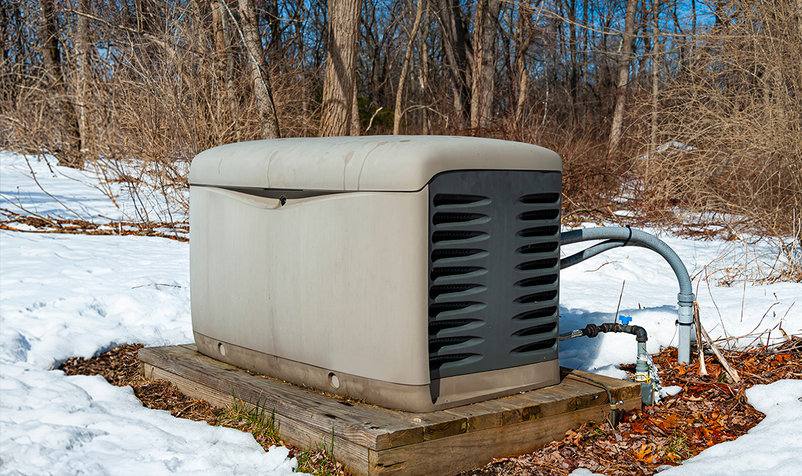 Old generator on a concrete pad in snow