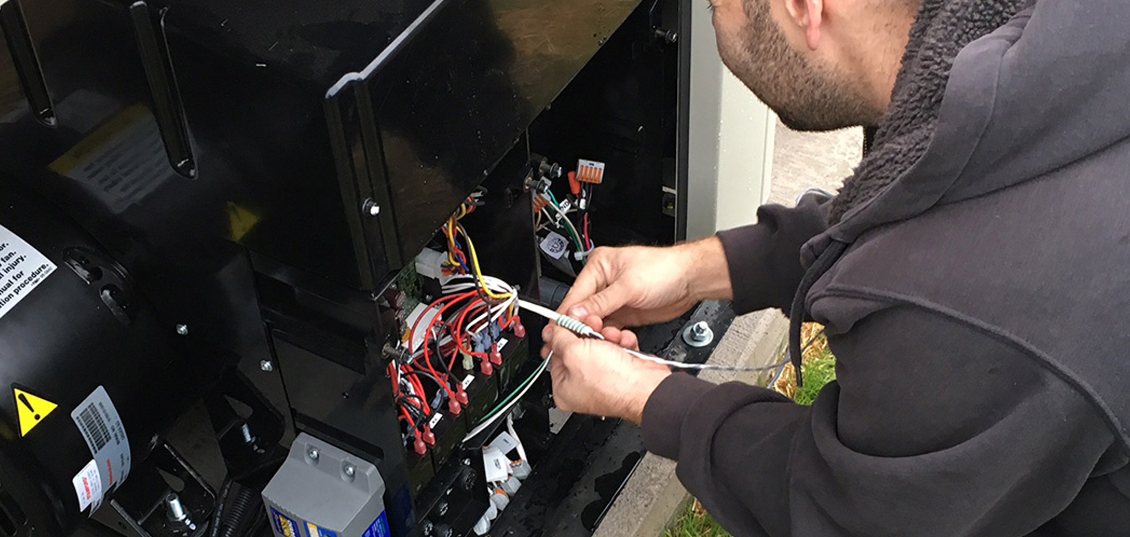 Tower Generator employee adjusting wires in a generator