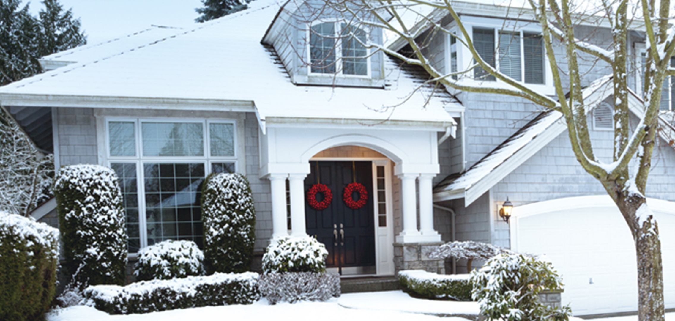 Residential home in winter with a thin layer of fresh snow covering everything.