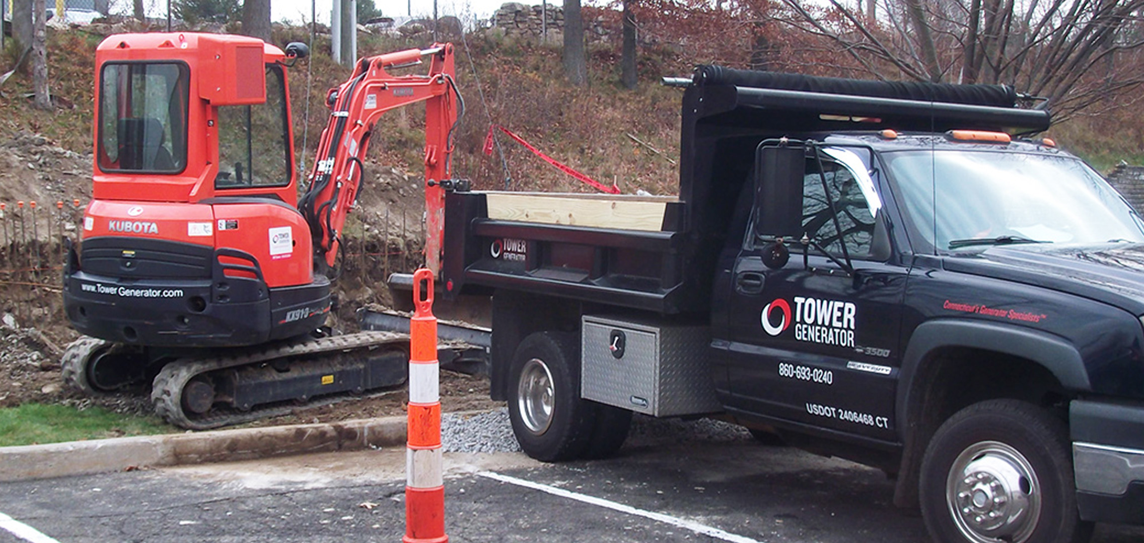 Black Tower Generator truck in the foreground and a red excavator vehicle in the background
