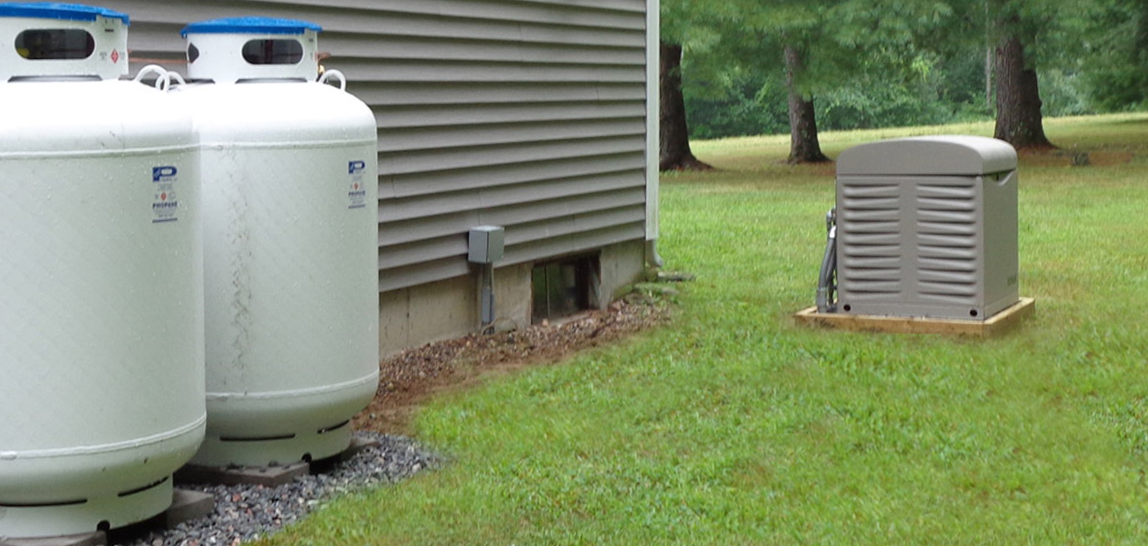 Residential generator next to two propane tanks
