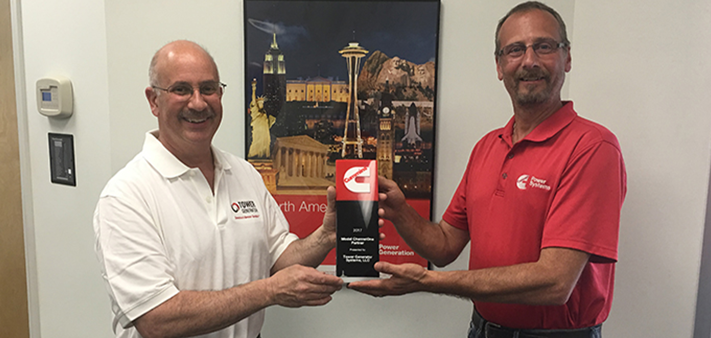 Two men from tower generator accepting an award for the number 1 Model ChannelOne Partner in the nation by Cummins Inc.