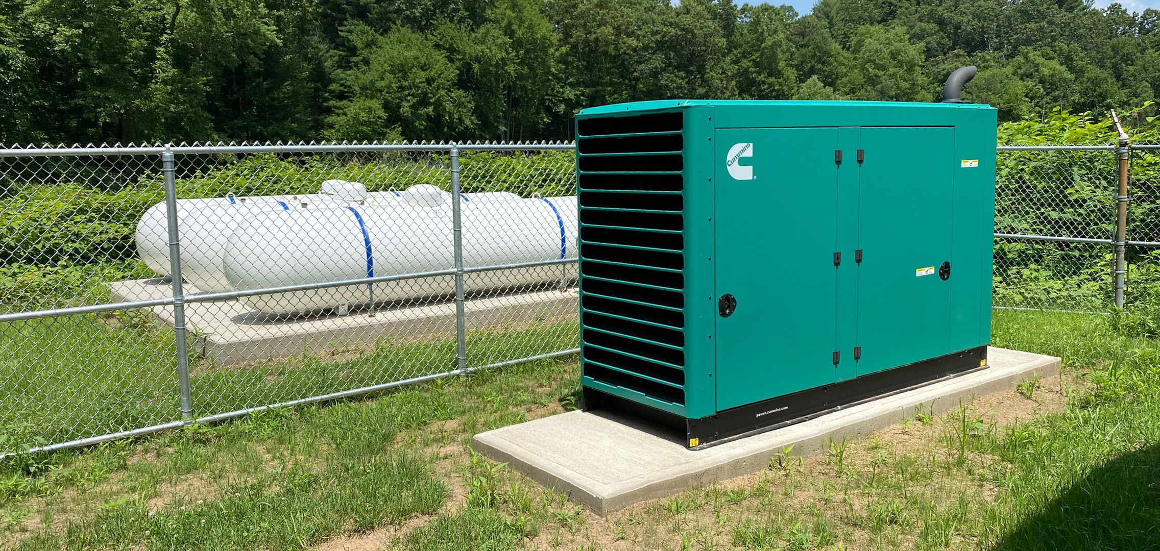 Commercial generator next to water booster pump station fenced in