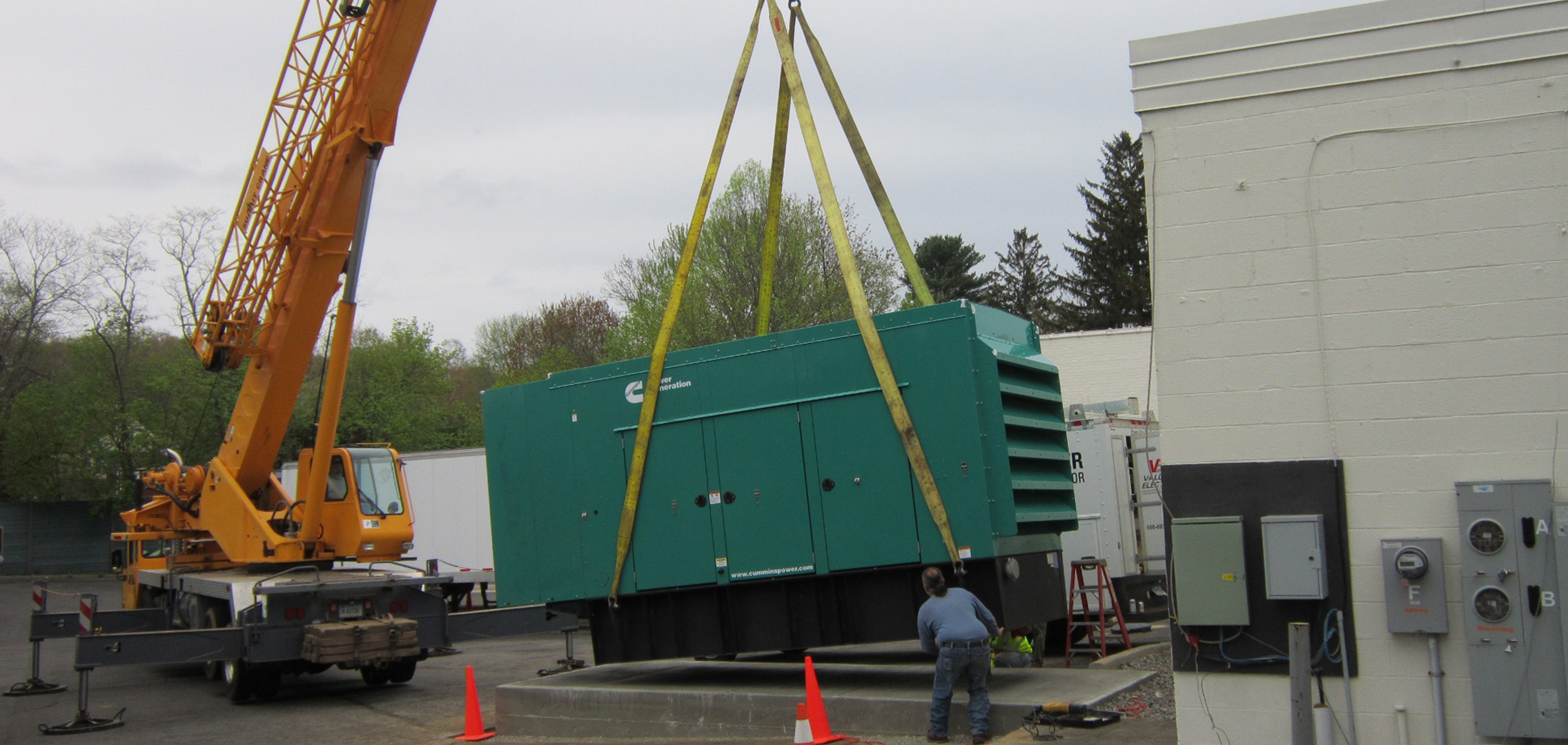 Commercial generator being airlifted onto the concrete base