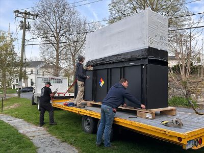 The Tower Generator Team unloading a commercial generator from the back of large truck