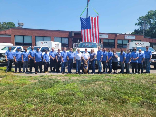 Tower Generator employees standing out side of the Tower Generator brick office building