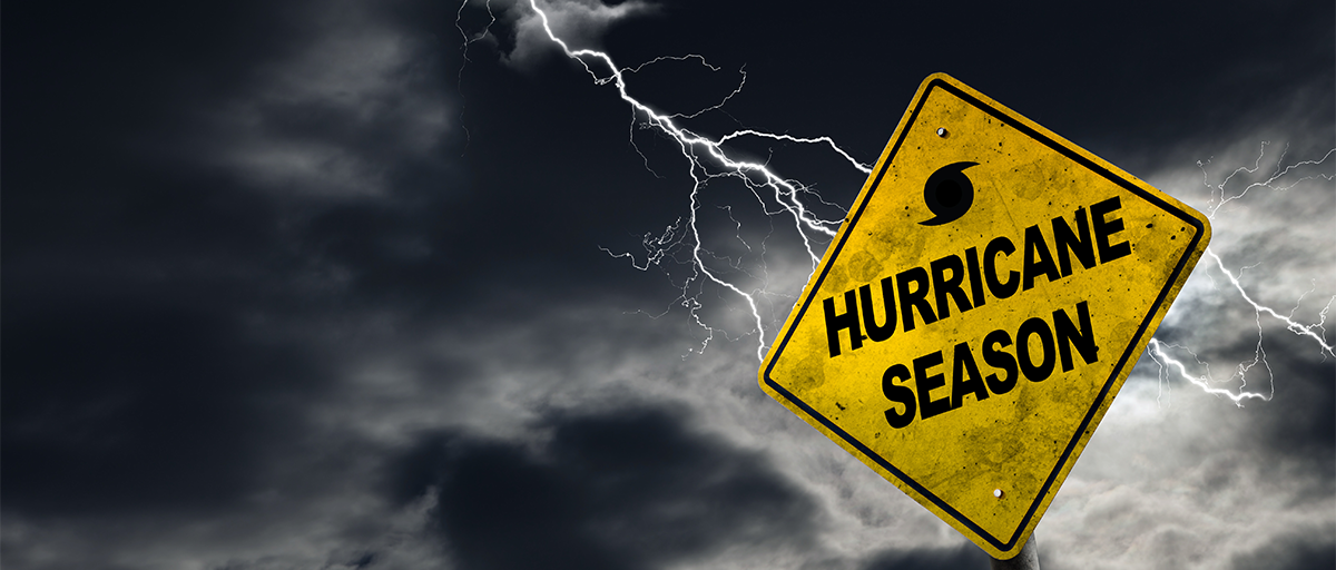 Dark clouds and lightning with a sign that reads "Hurricane Season".